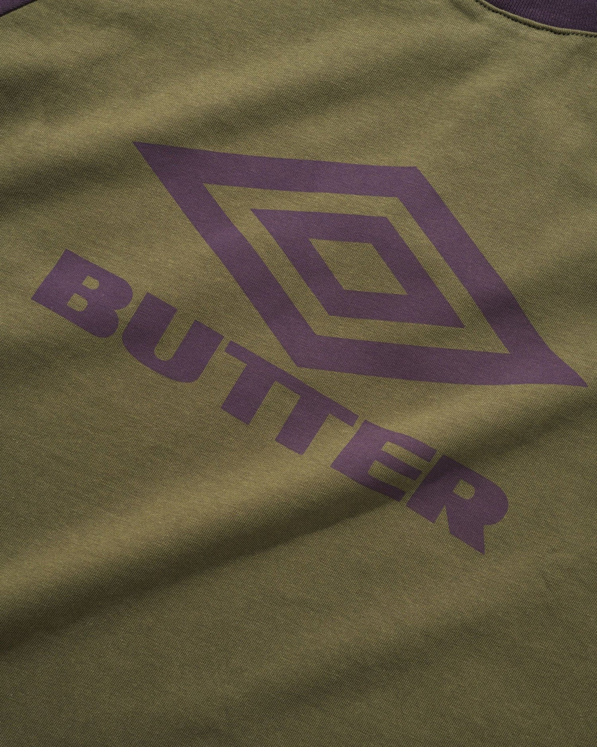 BUTTER GOODS x UMBRO Diamond Logo Raglan Tee Army/Eggplant